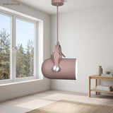 Pink spot pendant tilted above a wooden bench by a bright window