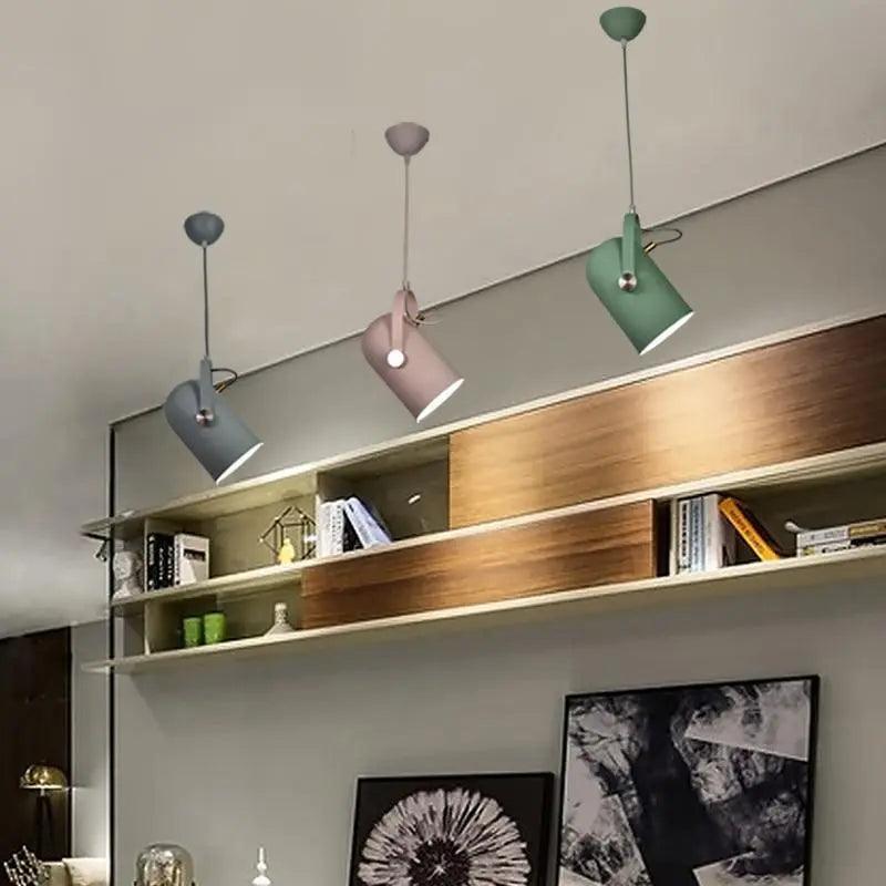 Row of coloured spot pendants above a long wooden shelf unit