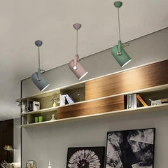 Row of coloured spot pendants above a long wooden shelf unit