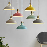 Six colored barn pendants hanging at mixed heights in a living room