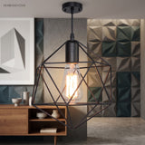Black cage pendant beside framed art and a low walnut sideboard