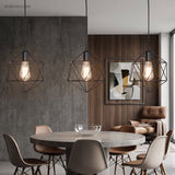 Three black cage pendants above a round dining table and chairs
