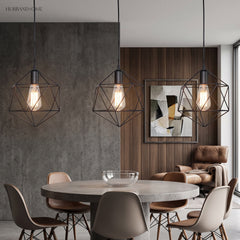 Three black cage pendants above a round dining table and chairs