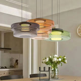 Amber green and smoke glass pendants over a kitchen island with flowers