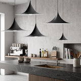 Two black flared pendants over a cafe counter and coffee machine