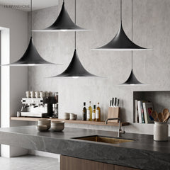 Two black flared pendants over a cafe counter and coffee machine