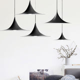 Three black flared pendants staggered above a white living room