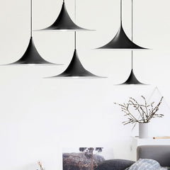 Three black flared pendants staggered above a white living room