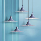 Grey flared pendants hung at staggered heights on a blue backdrop