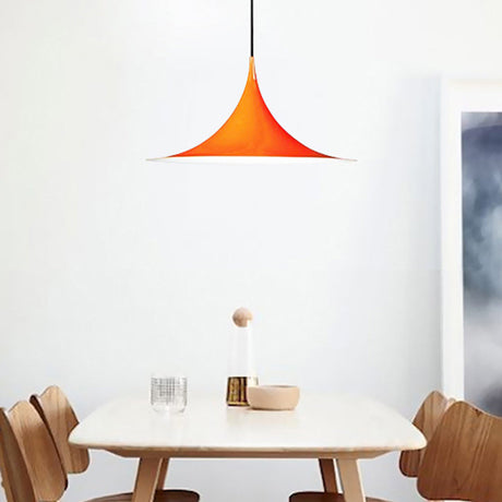 Orange flared pendant lit above a white dining table and chairs