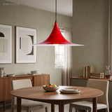 Red flared metal pendant above a round table with dining chairs