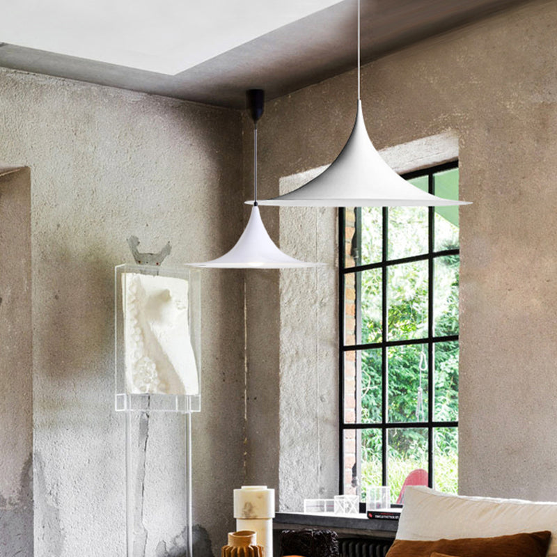 White and black flared pendants lit in a bright concrete room
