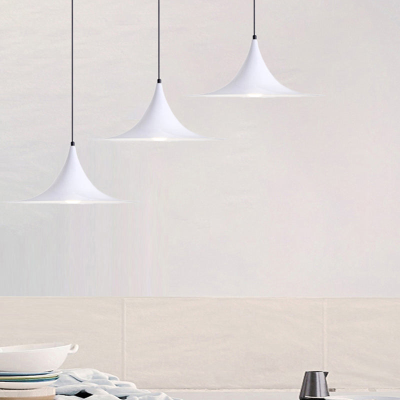 Three white flared pendants stepped down a pale tiled wall