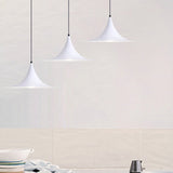 Three white flared pendants stepped down a pale tiled wall