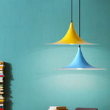 Yellow and blue flared pendants against a bright teal painted wall