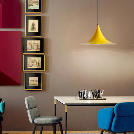 Yellow flared pendant lit above a table in a red walled room