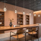 Amber and clear glass pendants in a row above a bar counter