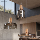 Smoke and amber glass pendants with wood tops in a concrete room