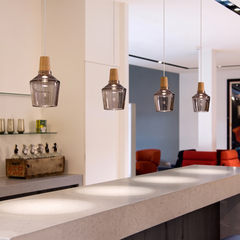 Amber glass pendants in a row above a light kitchen counter