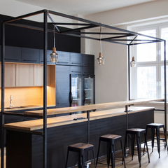 Glass pendants hanging from a black frame above a kitchen island