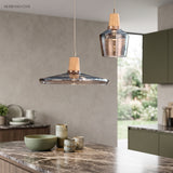 Wide smoke glass saucer pendant lit above a marble kitchen island