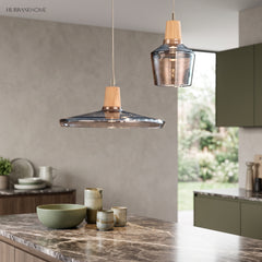Wide smoke glass saucer pendant lit above a marble kitchen island