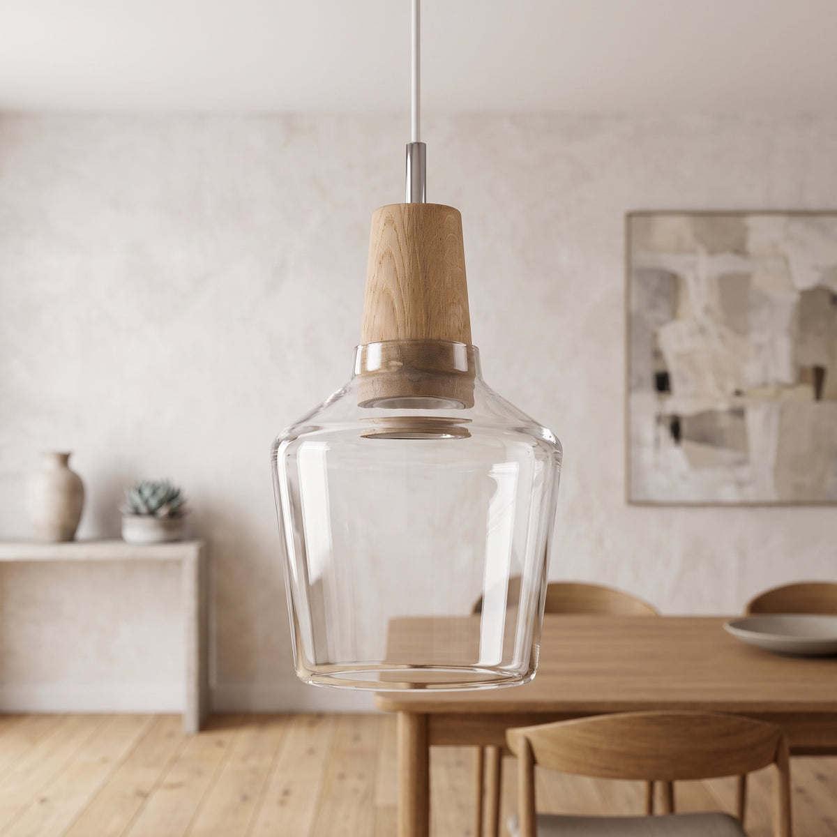 Clear glass pendant with a wood top hanging above a pale dining table
