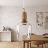 Clear glass pendant with a wood top hanging above a pale dining table