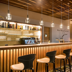 Clear glass pendants in a long row above a timber bar front