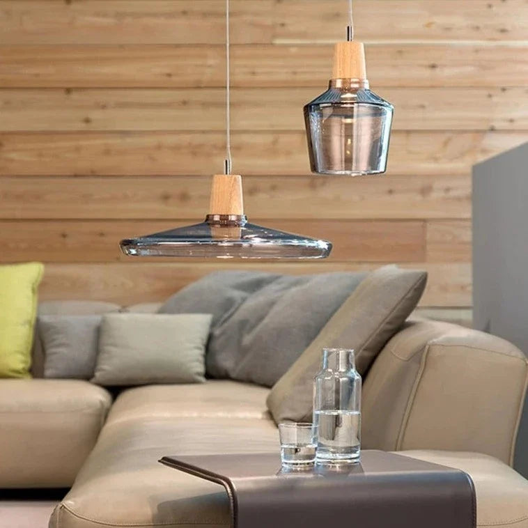 Smoke glass pendants with wood tops above a pale leather sofa