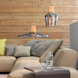 Smoke glass pendants with wood tops above a pale leather sofa