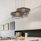 Cluster of smoke grey three-layer glass pendants over a white kitchen island