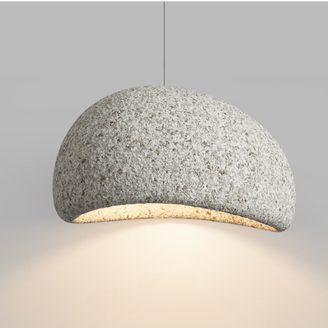 Grey speckled dome pendant lit warm against a pale wall