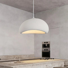 White dome pendant lit above a stone kitchen bench and tap