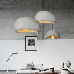 Three white dome pendants lit above a sofa in a bright room