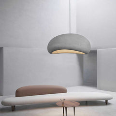 White dome pendant lit above a low sofa in a curved white room