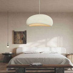 White dome pendant lit above a bed with a timber bench