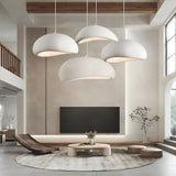 Cluster of white dome pendants lit above a round rug and sofa