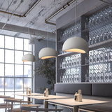 Row of white dome pendants lit above a bar counter
