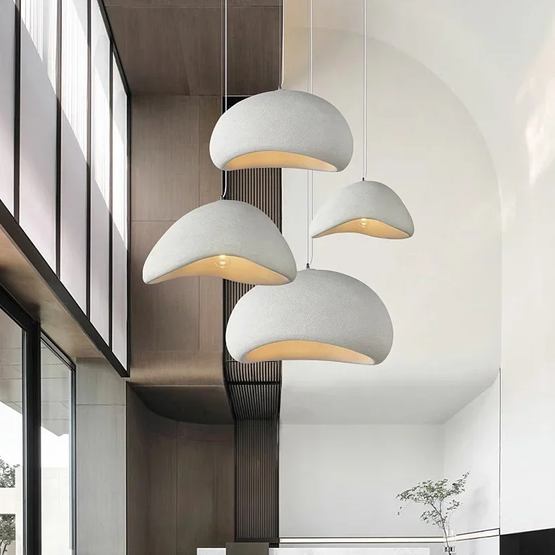 Three white dome pendants lit beside tall windows in a loft