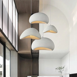 Three white dome pendants lit beside tall windows in a loft