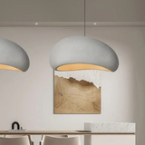 Grey speckled dome pendant lit above a dining table