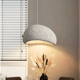 Grey dome pendant lit above a table in a room with blinds
