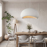 White wabi sabi pendant lit above a wooden dining table and chairs