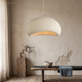 White dome pendant lit above a low bench and ceramic vases