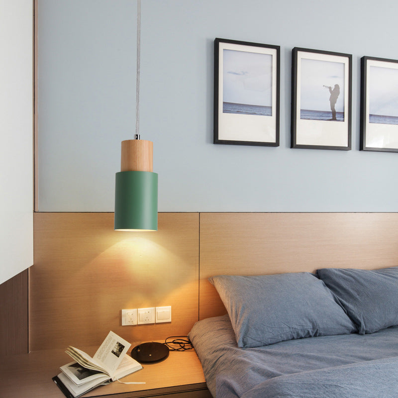 Green pendant used as a bedside light above a timber headboard