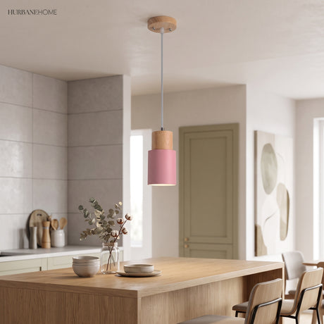 Pink cylinder pendant with a wood top above a kitchen island