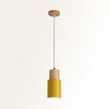 Studio shot of the yellow metal cylinder pendant on cream