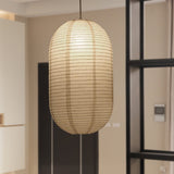 Oval capsule paper lantern hanging beside a black framed doorway