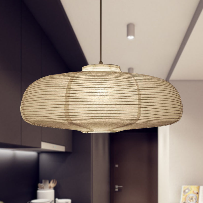 Wide disc paper lantern lit above a kitchen in a dark room